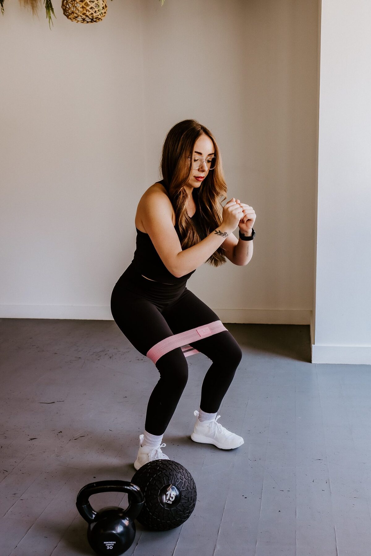 Woman doing a squat with resistance bands